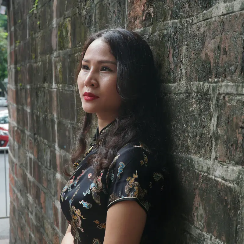 Woman standing against a brick wall