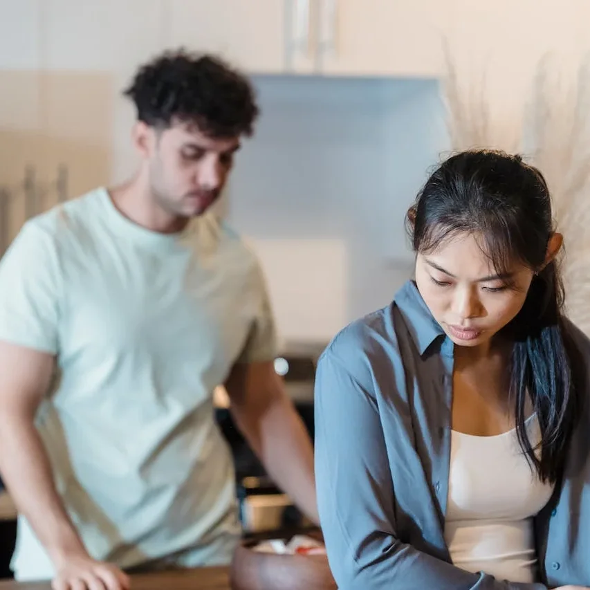 Couple in a kitchen with woman facing away upset