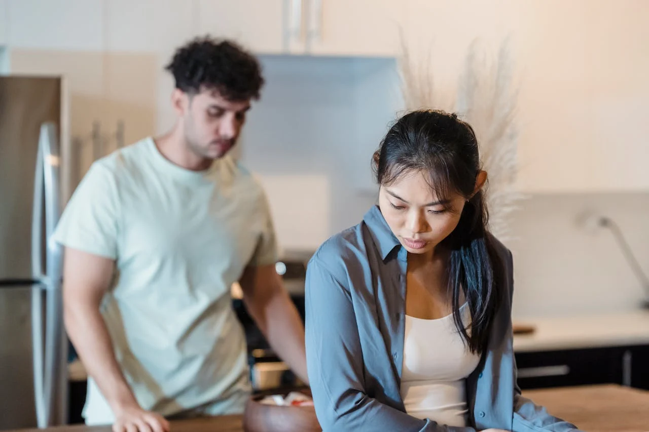 Couple in a kitchen with woman facing away upset