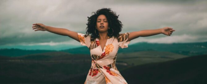 Woman with arms spread wide and eyes closed